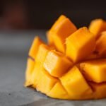a sliced mango cubes on gray surface